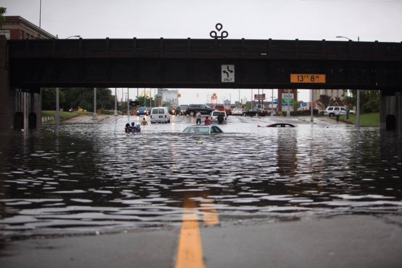 Flooding submerges dozens of cars, closes highways, impedes