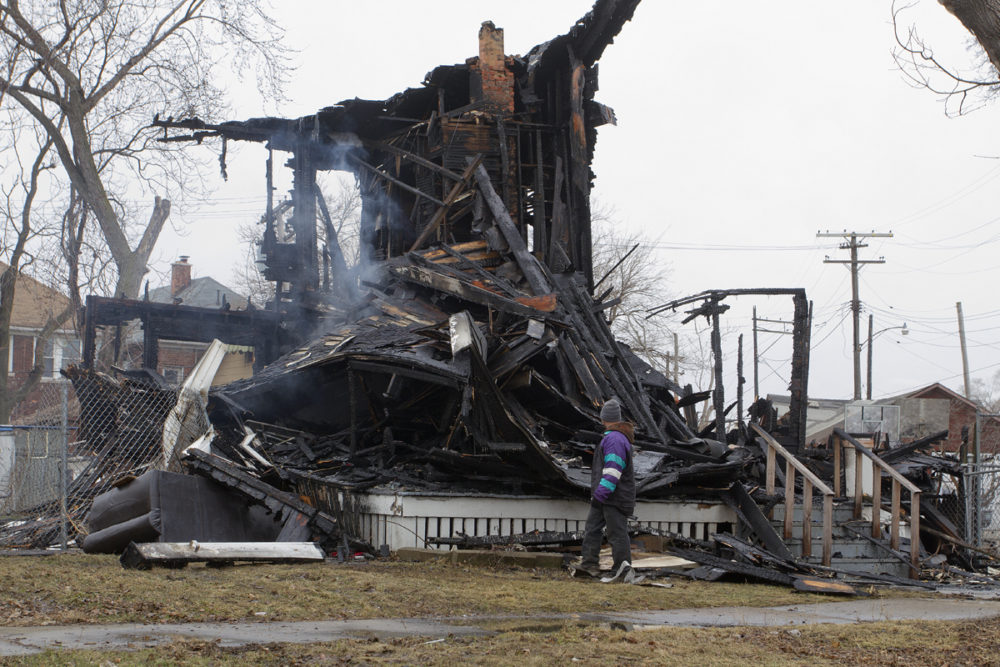 A scrapper looks for metal after fire tore through this house at 2577 Stair. Steve Neavling/MCM