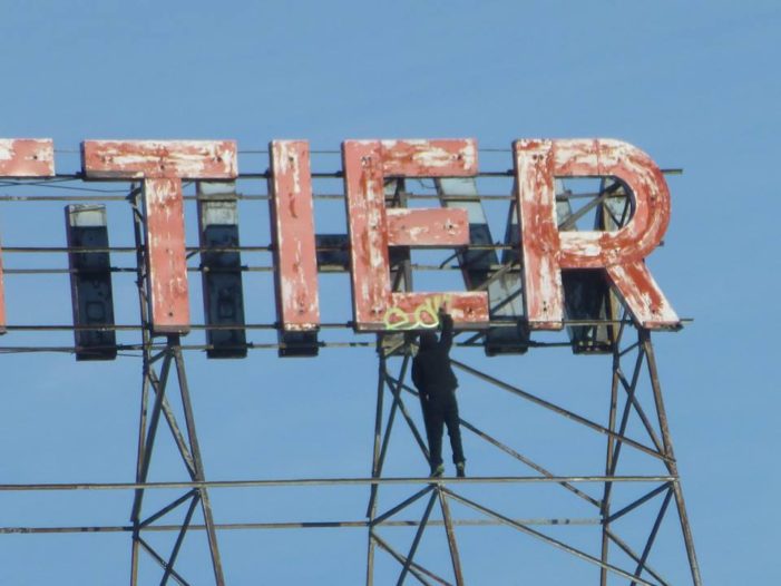 Graffiti vandal defaces iconic sign atop historic Whittier near downtown Detroit in daylight