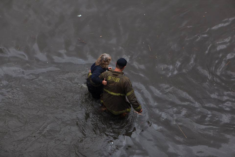 A Detroit firefighter rescues a woman after I-75 flooded. 