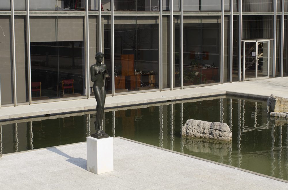 A sculpture surrounded by the reflecting pool. 