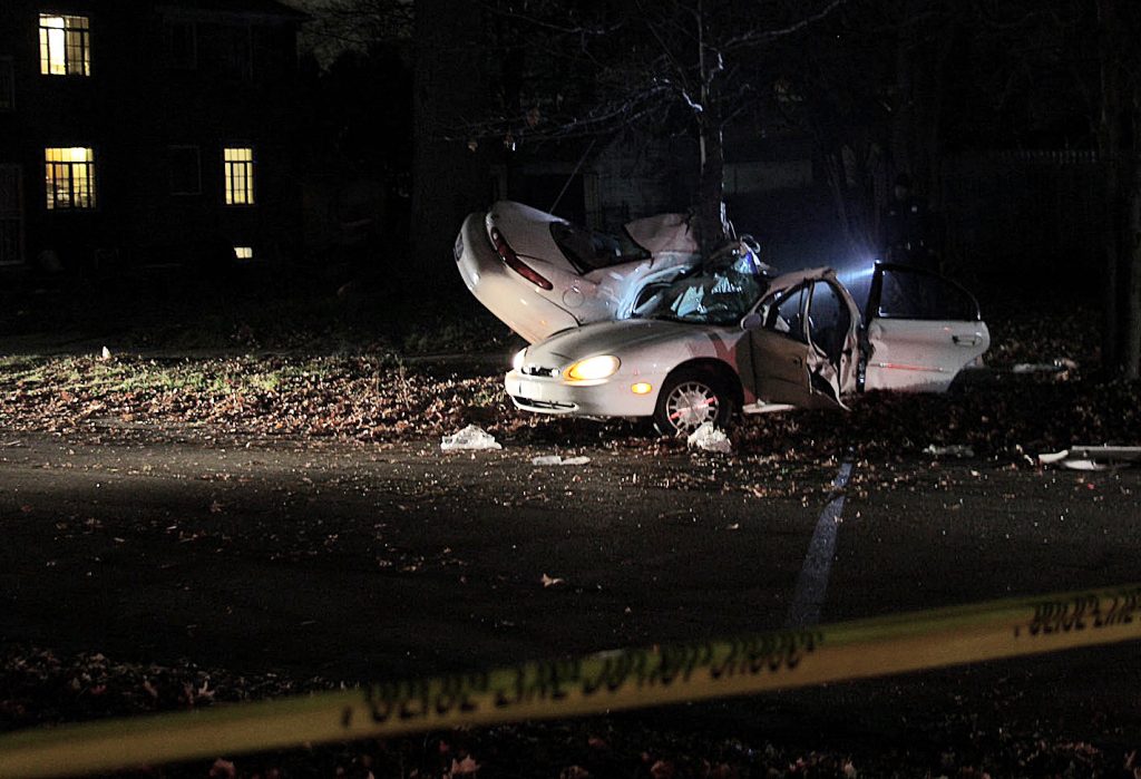 The white sedan was sliced in half after hitting a tree during a police chase in Detroit. Photo by Michael Brouwer. 