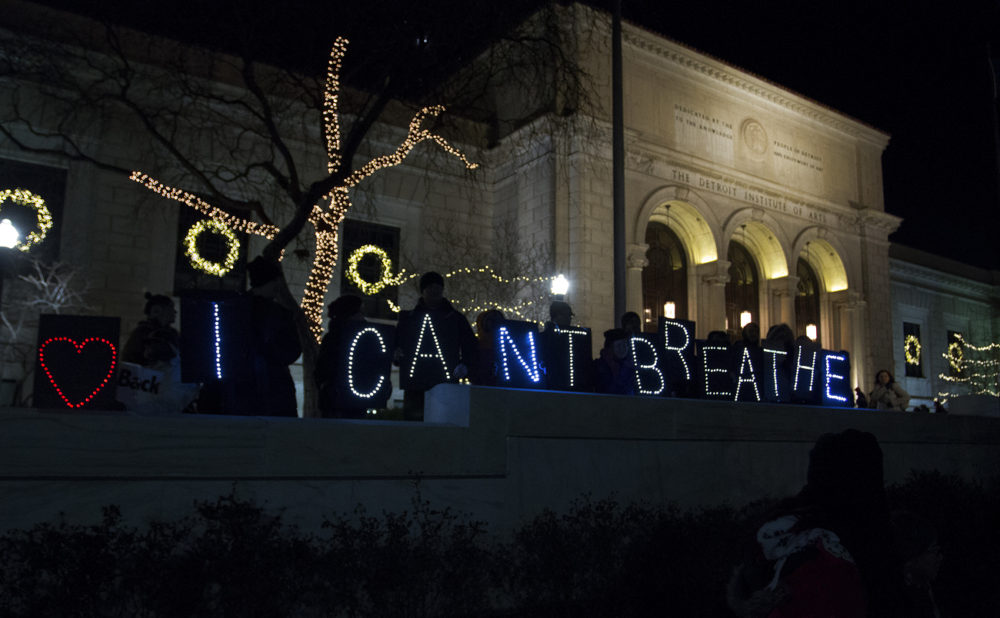 Protesters hold up signs that spell out, "I CAN'T BREATHE," in front of the Detroit Institute of Arts on Noel Night in Detroit. 
