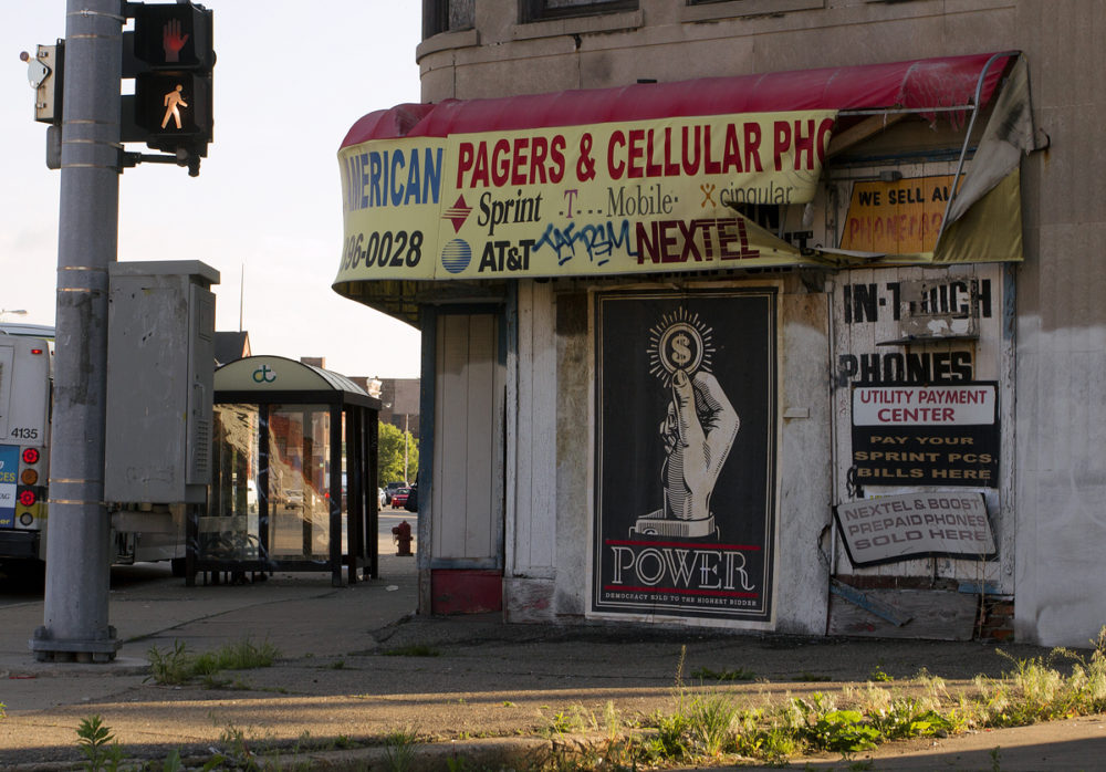 A Fairey mural mocking consumerism and power was posted on a vacant building on Gratiot. Photos by Steve Neavling. 